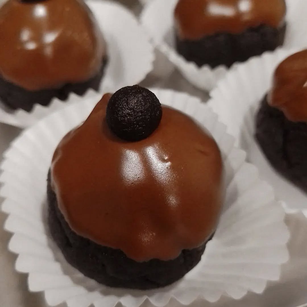 Bolos individuais com cobertura de chocolate brilhante, em formas de papel